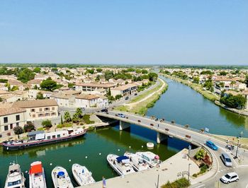 High angle view of boats in river against buildings