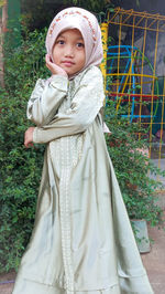 Portrait of young woman standing on field