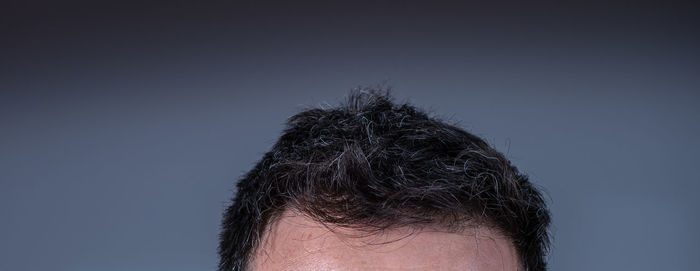 Close-up portrait of a man against blue background