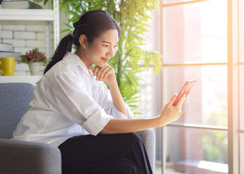 Young woman sitting on chair at home