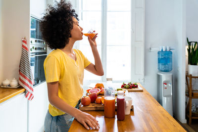 Young woman drinking juice at office