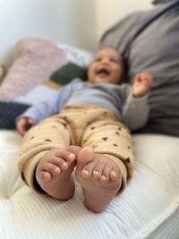 High angle view of baby boy toes feet sleeping on cushions at home