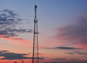 Low angle view of silhouette communications tower against sky during sunset