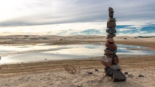 Stack of rocks on beach against sky