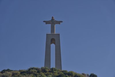 Low angle view of cross against clear blue sky