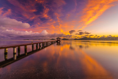 Scenic view of sea against dramatic sky during sunset