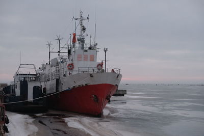 Ship moored on sea against sky during winter