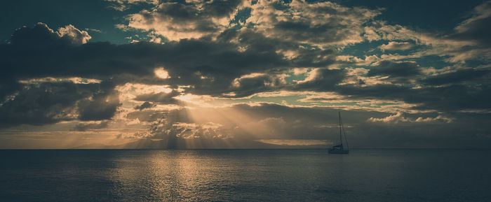 Boat sailing in sea against sky during sunset