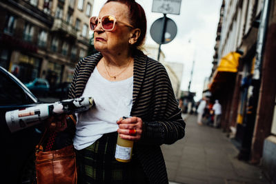 Man wearing sunglasses standing on street in city