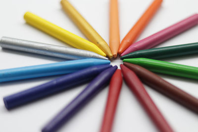 Close-up of multi colored pencils on white table