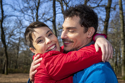 Young couple is hugging happy in the woods. couple have fun while hiking in the woods in italy.