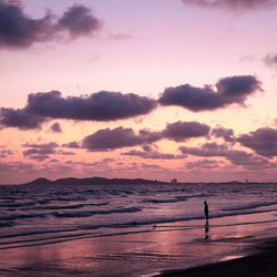 Silhouette person on beach against sky during sunset