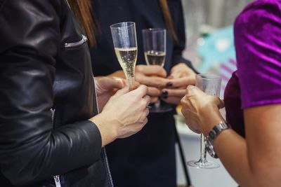 Midsection of friends with champagne in party