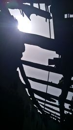 Low angle view of silhouette people standing on railing against sky