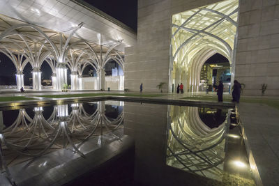 Reflection of illuminated building on floor at night