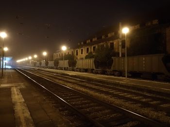 Illuminated railroad station platform at night