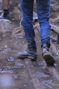 Low section of man standing in puddle