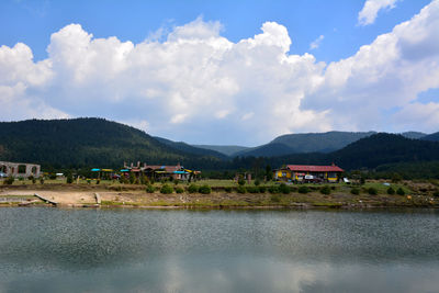 Scenic view of lake by buildings against sky
