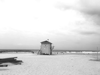 Lifeguard hut on beach against sky