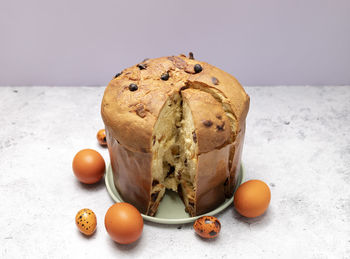 Easter panettone italian cake on table with colored easter hen eggs. fruitcake, sweet bread