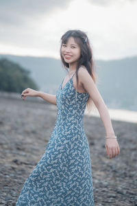 Portrait of young woman standing at beach