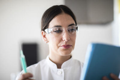 Scientist female with lab glasses, tablet and sample in a lab