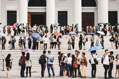 People walking on street against buildings in city