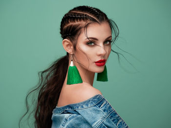 Close-up of young woman against blue background