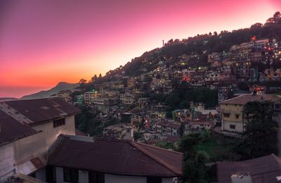 Town against sky at sunset