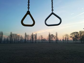 Silhouette of swing against sky during sunset