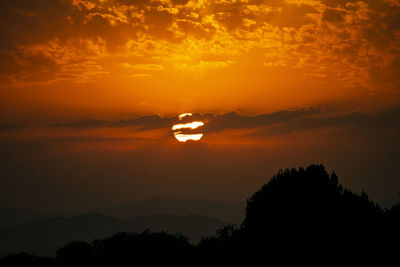 Silhouette trees against romantic sky at sunset