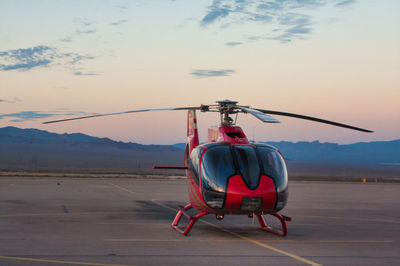 Helicopter on airport runway against sky