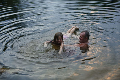 A little girl learning to swim at sunet