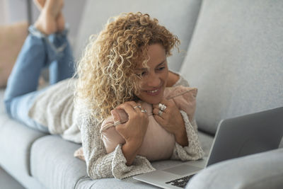 Portrait of young woman sitting on bed at home