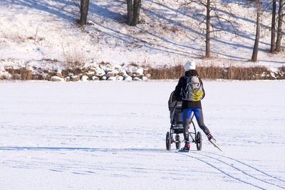 Full length of woman skiing on snow covered field