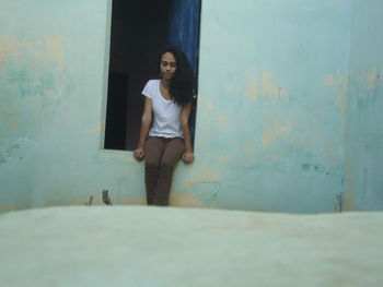 Thoughtful young woman sitting at window