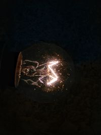 Close-up of illuminated lamp against black background