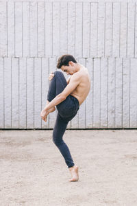 Full length of man dancing against wall