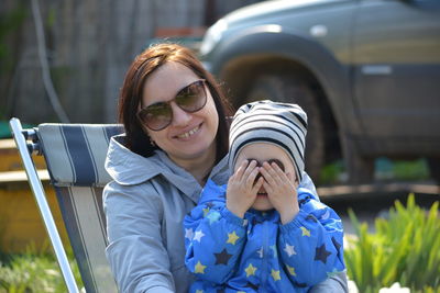 Close-up of mother and son sitting on chair