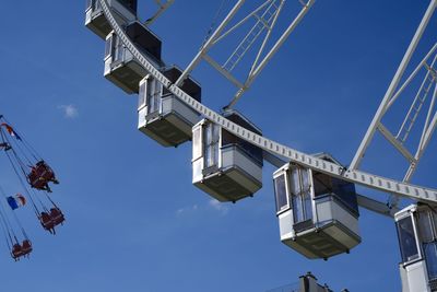 Low angle view of ferris wheel against blue sky