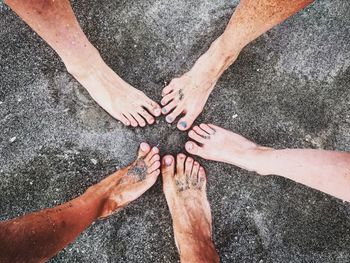 Low section of friends standing on sand