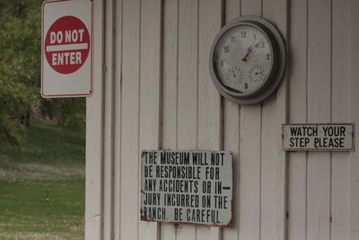 Warning signs and clock on wooden wall at ranch