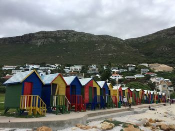 Multi colored houses on beach by buildings against sky