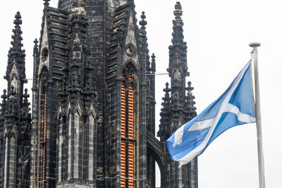 Low angle view of flags against buildings in city