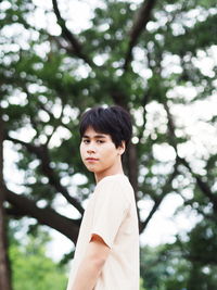 Low angle view of a boy against tree