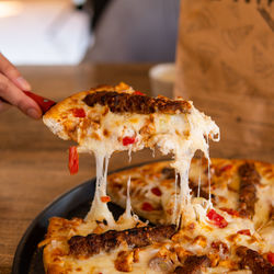 Close-up of hand holding pizza