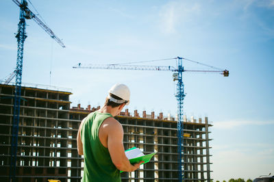 Man standing against construction buildings