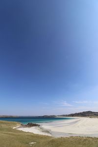 Scenic view of beach against blue sky