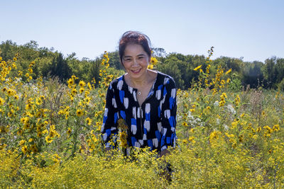 Portrait of smiling senior woman standing on field