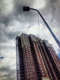 Low angle view of modern building against cloudy sky